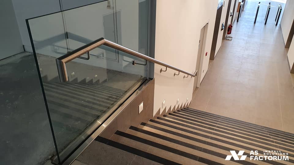 Glass balustrade with a stainless steel handrail on an interior staircase