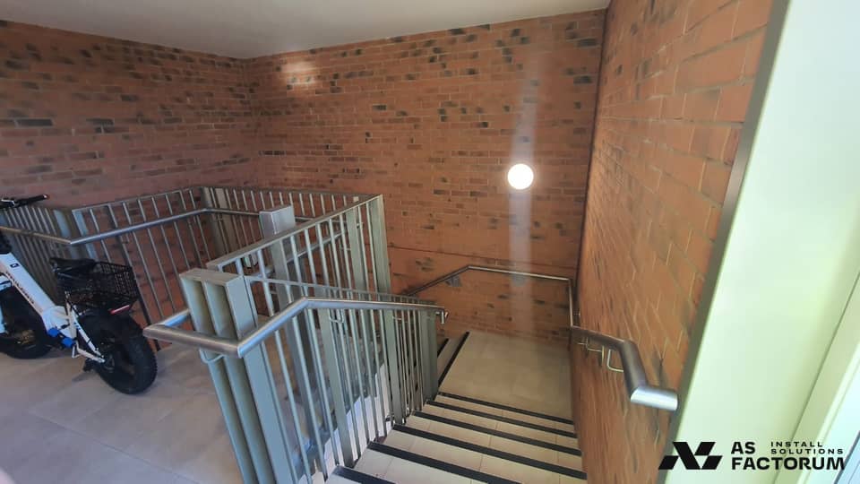 Stairwell landing with a metal balustrade and an electric bike leaning against the wall