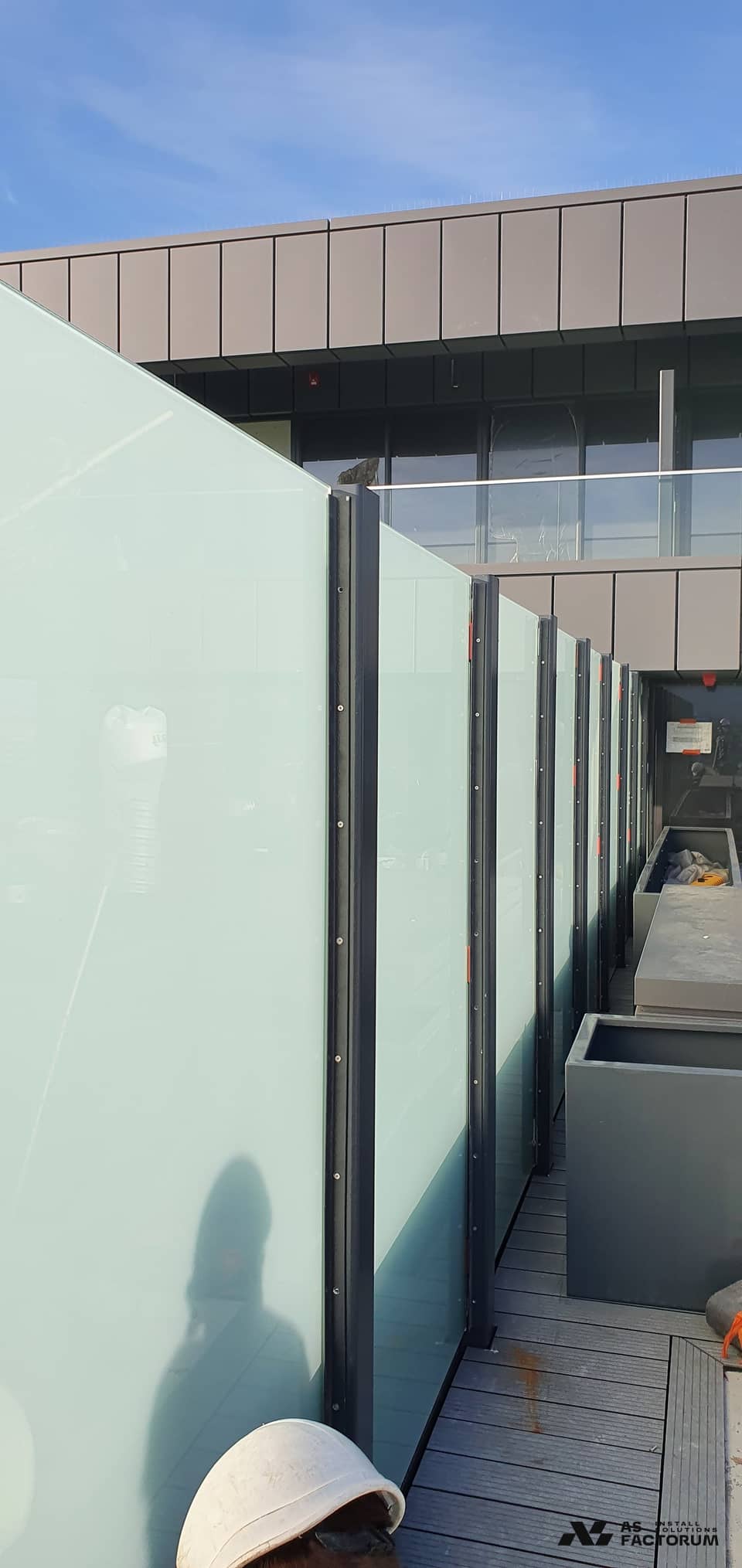 Frosted glass screens on metal posts installed on a roof terrace