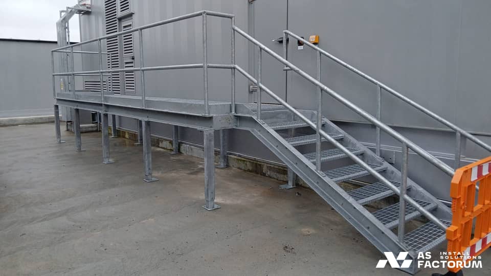 Wide view of the galvanised stair and raised platform fitted beside a grey container