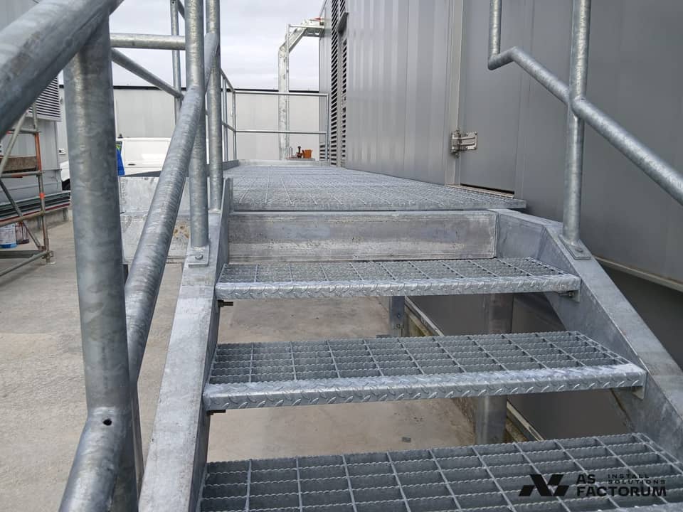 Close-up of the galvanised grating treads and handrail of an outdoor stair