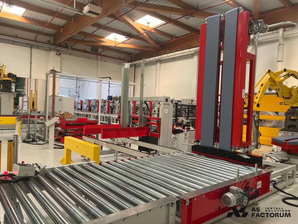 Roller conveyor line with a red palletising unit in a production hall