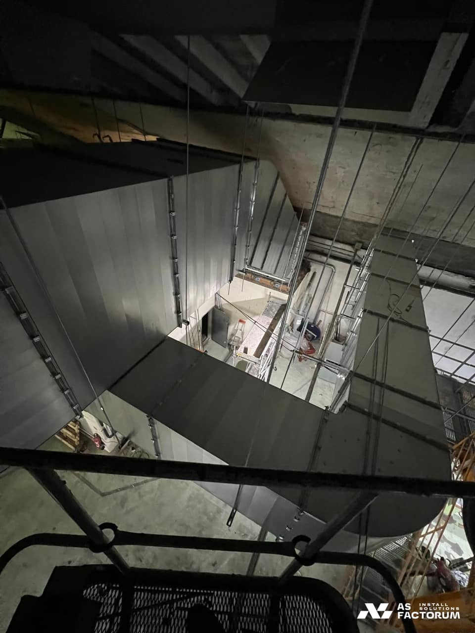 Rectangular ducts seen in dim light from a lift platform inside a hall