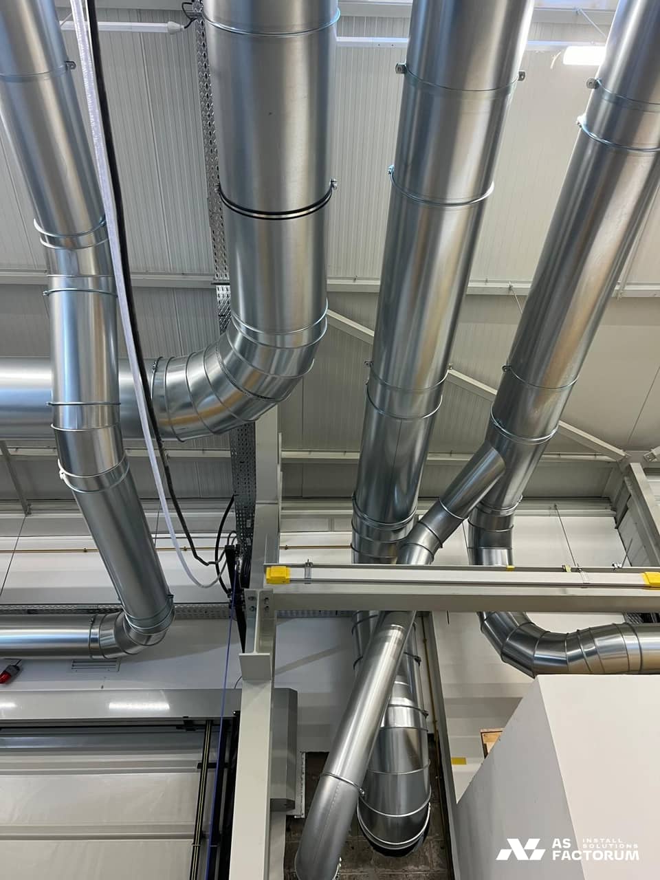 Vertical round ducts with elbows, held by a supporting steel frame